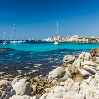 Turquoise bay with yachts and rocky coastline in Corsica