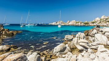 Turquoise bay with yachts and rocky coastline in Corsica