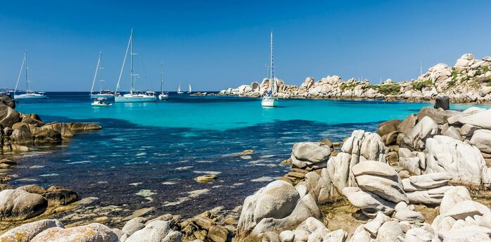Turquoise bay with yachts and rocky coastline in Corsica