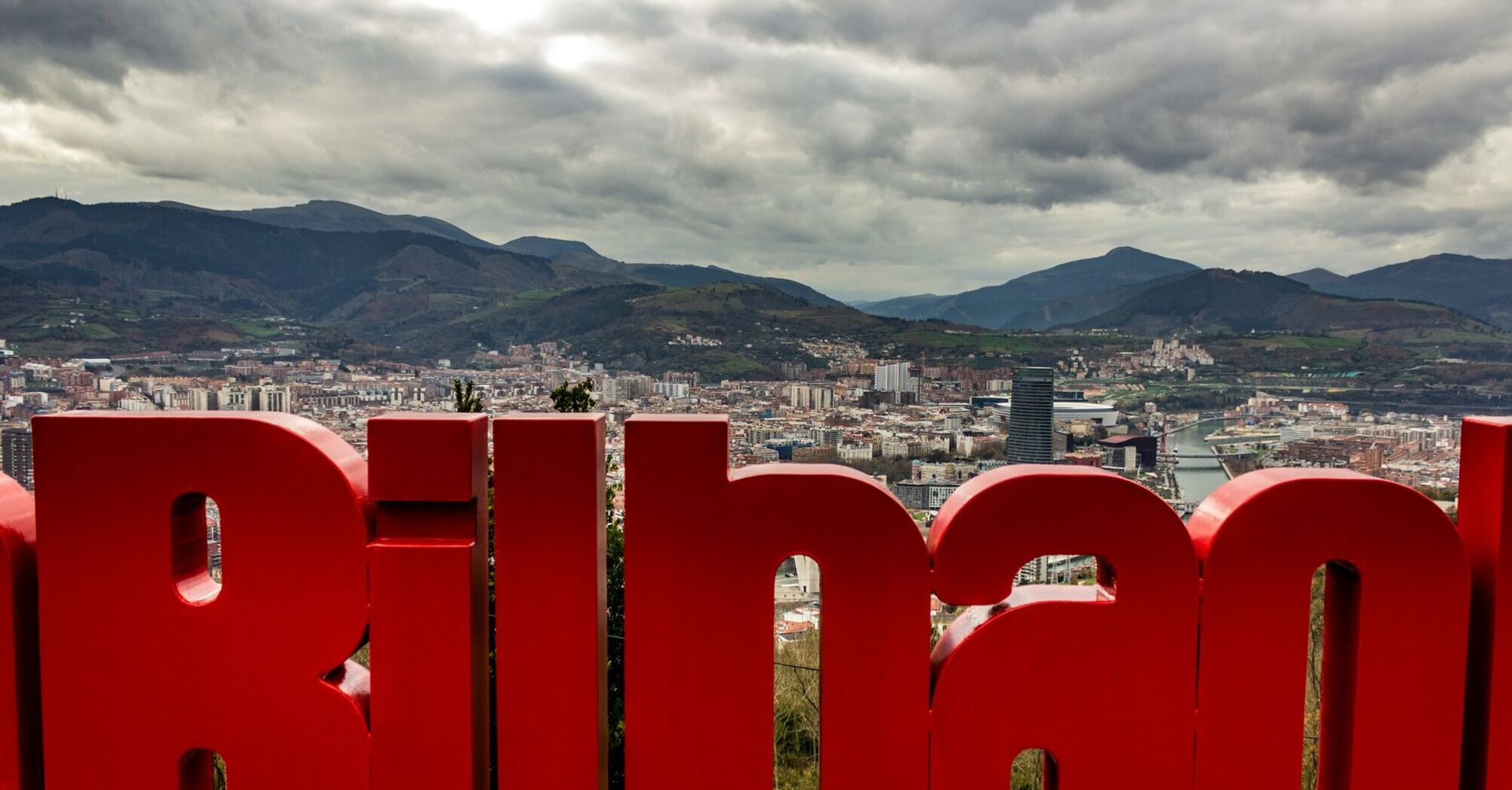 Bilbao city view with mountains and red sign