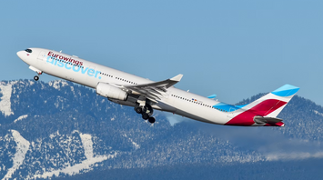 Eurowings aircraft departing over snowy mountains