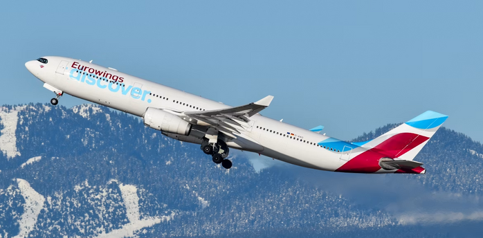 Eurowings aircraft departing over snowy mountains