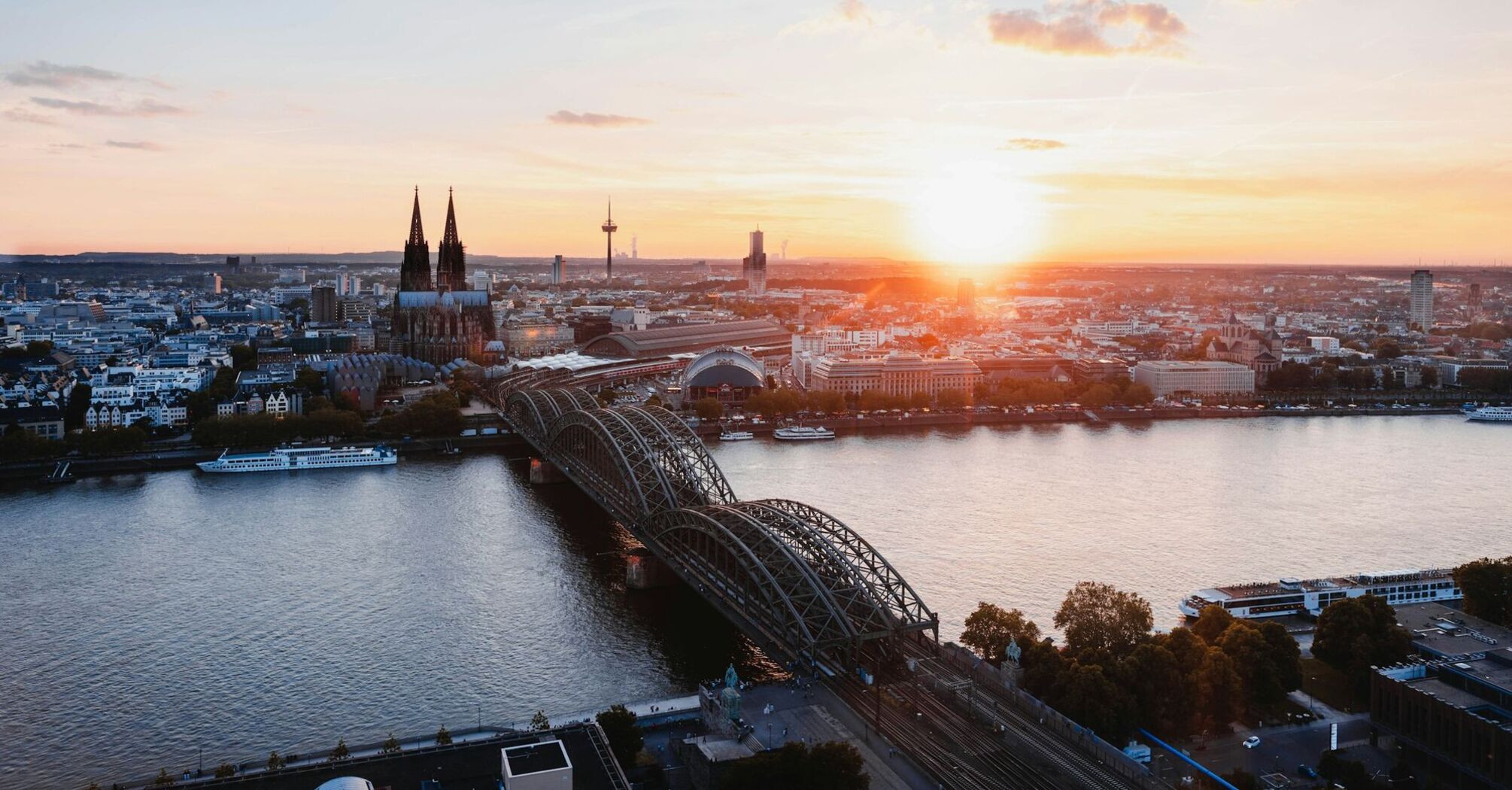 Cologne skyline with Hohenzollern Bridge at sunset