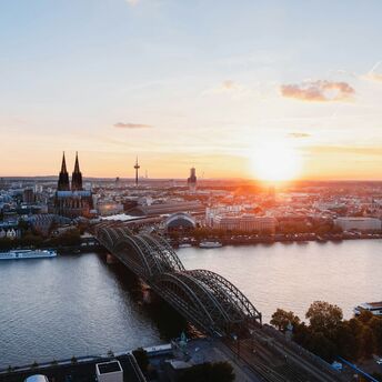 Cologne skyline with Hohenzollern Bridge at sunset