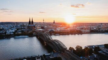 Cologne skyline with Hohenzollern Bridge at sunset