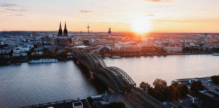 Cologne skyline with Hohenzollern Bridge at sunset