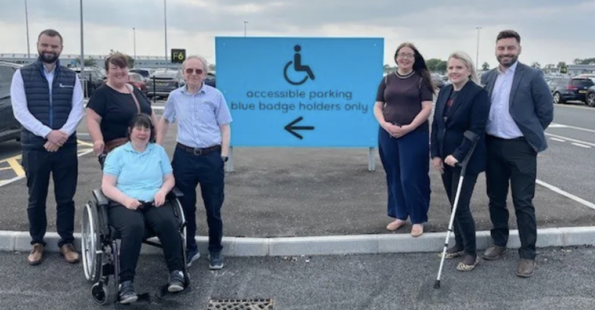 People beside Belfast Airport’s accessible parking sign