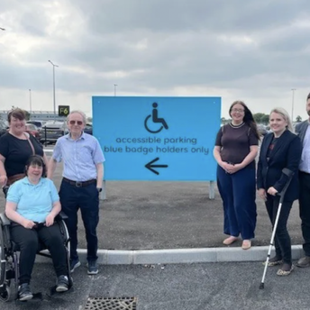 People beside Belfast Airport’s accessible parking sign