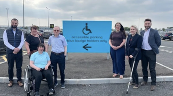 People beside Belfast Airport’s accessible parking sign