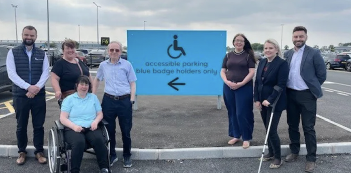 People beside Belfast Airport’s accessible parking sign