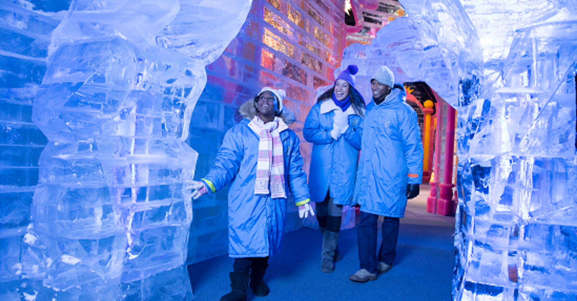 Visitors exploring hand-carved ice sculptures at Gaylord Rockies