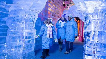 Visitors exploring hand-carved ice sculptures at Gaylord Rockies