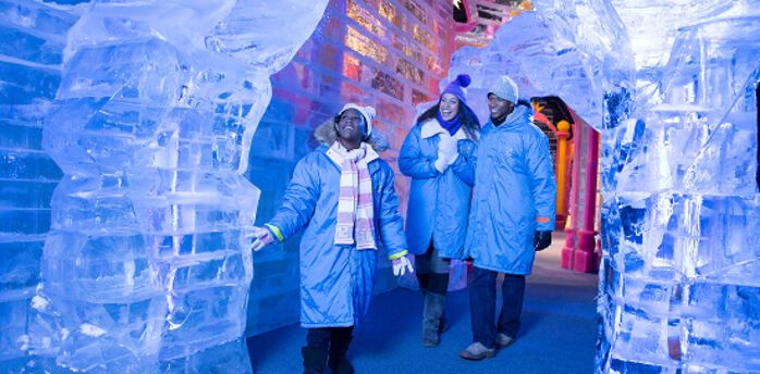 Visitors exploring hand-carved ice sculptures at Gaylord Rockies
