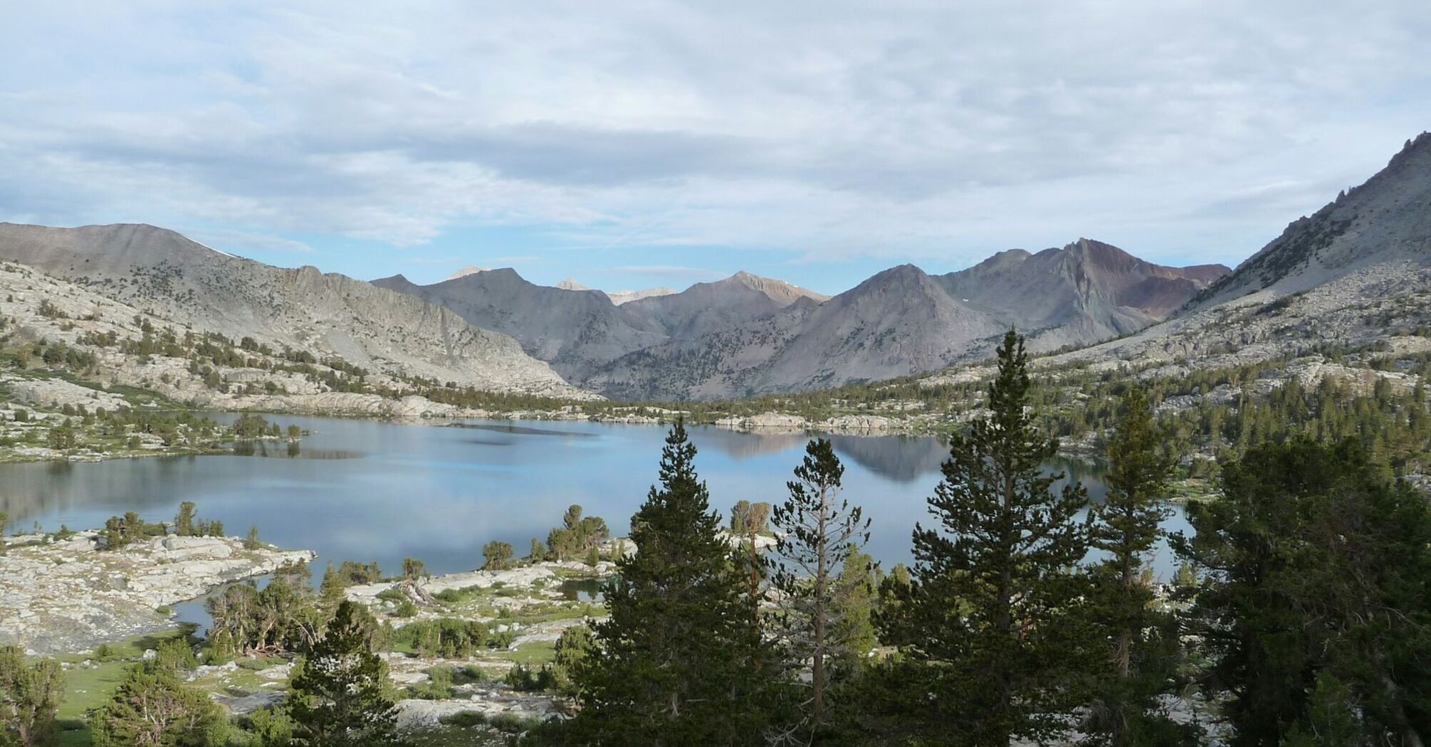Mountain lake surrounded by rocky peaks and pine trees