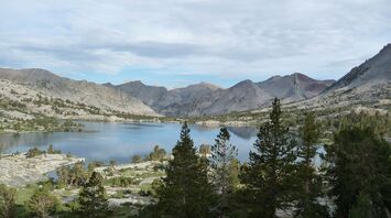Mountain lake surrounded by rocky peaks and pine trees