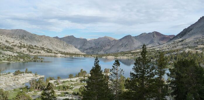 Mountain lake surrounded by rocky peaks and pine trees