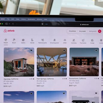Airbnb accommodation listings on a laptop