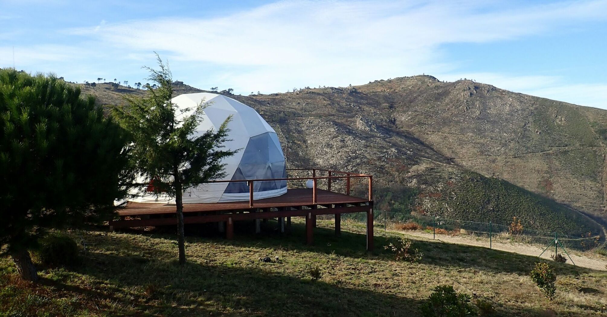 Glamping dome in a hilly coastal landscape