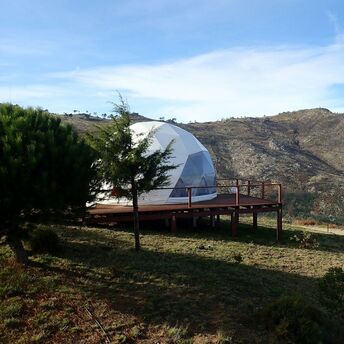 Glamping dome in a hilly coastal landscape