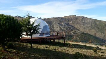 Glamping dome in a hilly coastal landscape