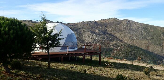 Glamping dome in a hilly coastal landscape