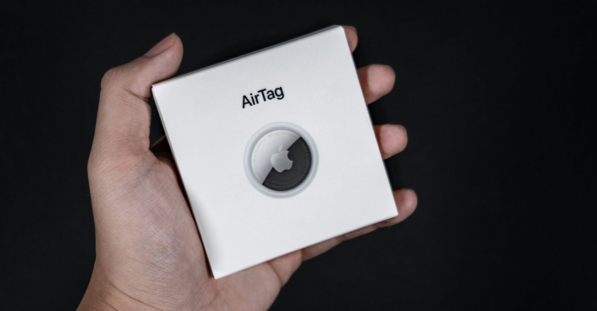 Apple AirTag box held in hand