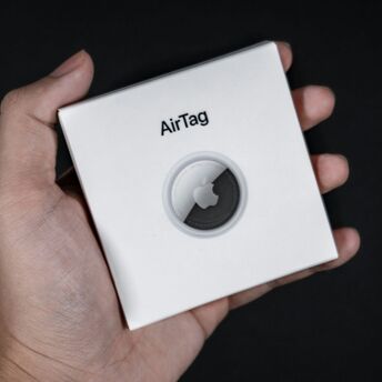 Apple AirTag box held in hand