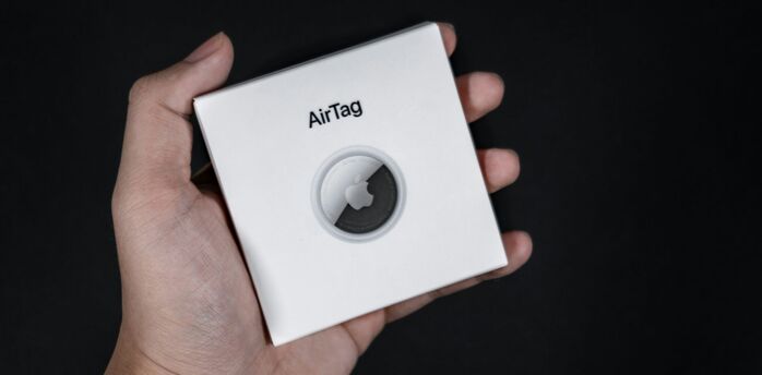 Apple AirTag box held in hand