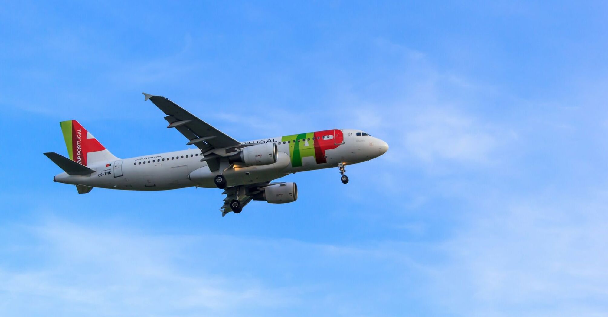 TAP Air Portugal aircraft landing in blue sky