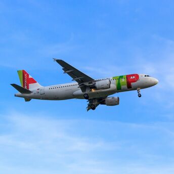 TAP Air Portugal aircraft landing in blue sky