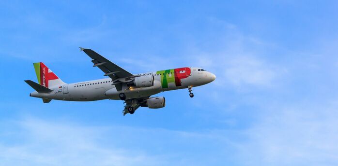 TAP Air Portugal aircraft landing in blue sky