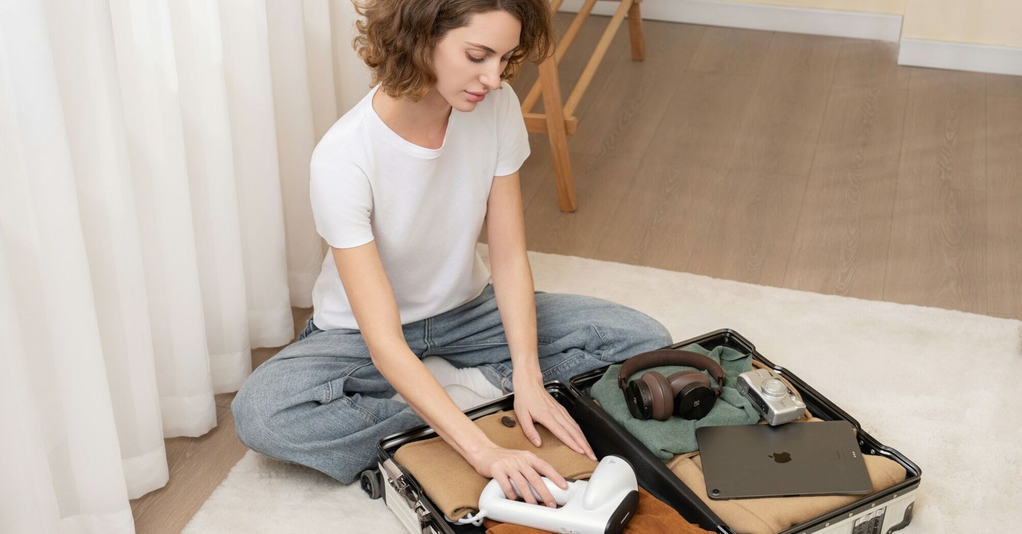 Woman packing travel essentials in a suitcase