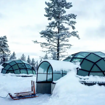 Glass igloos surrounded by snow in Finland