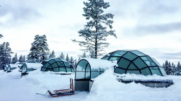 Glass igloos surrounded by snow in Finland