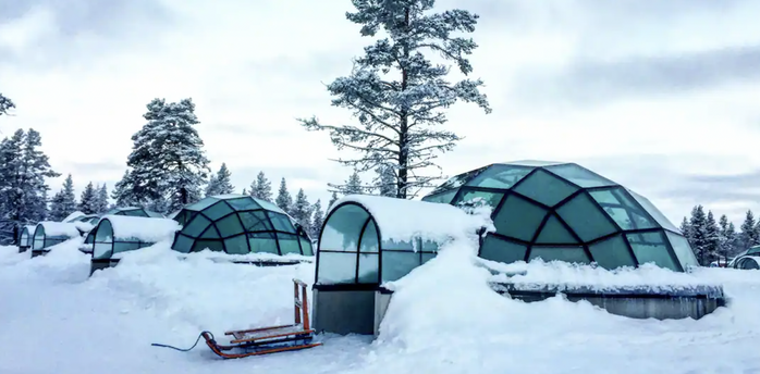 Glass igloos surrounded by snow in Finland