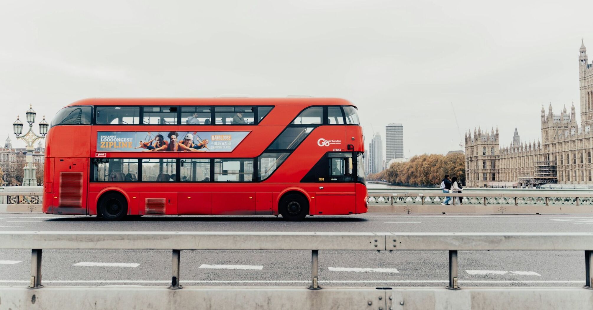 Red double-decker bus crossing Westminster Bridge in London