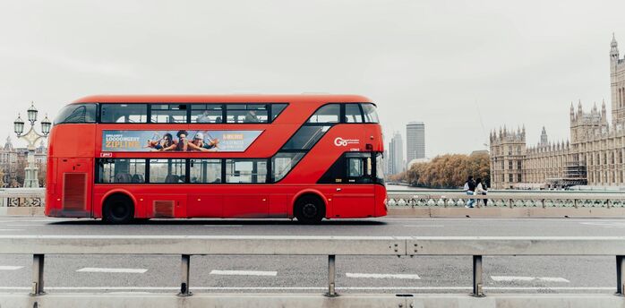 Red double-decker bus crossing Westminster Bridge in London