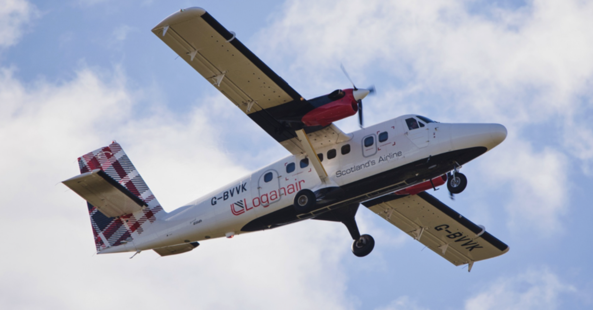Loganair aircraft flying against a cloudy sky