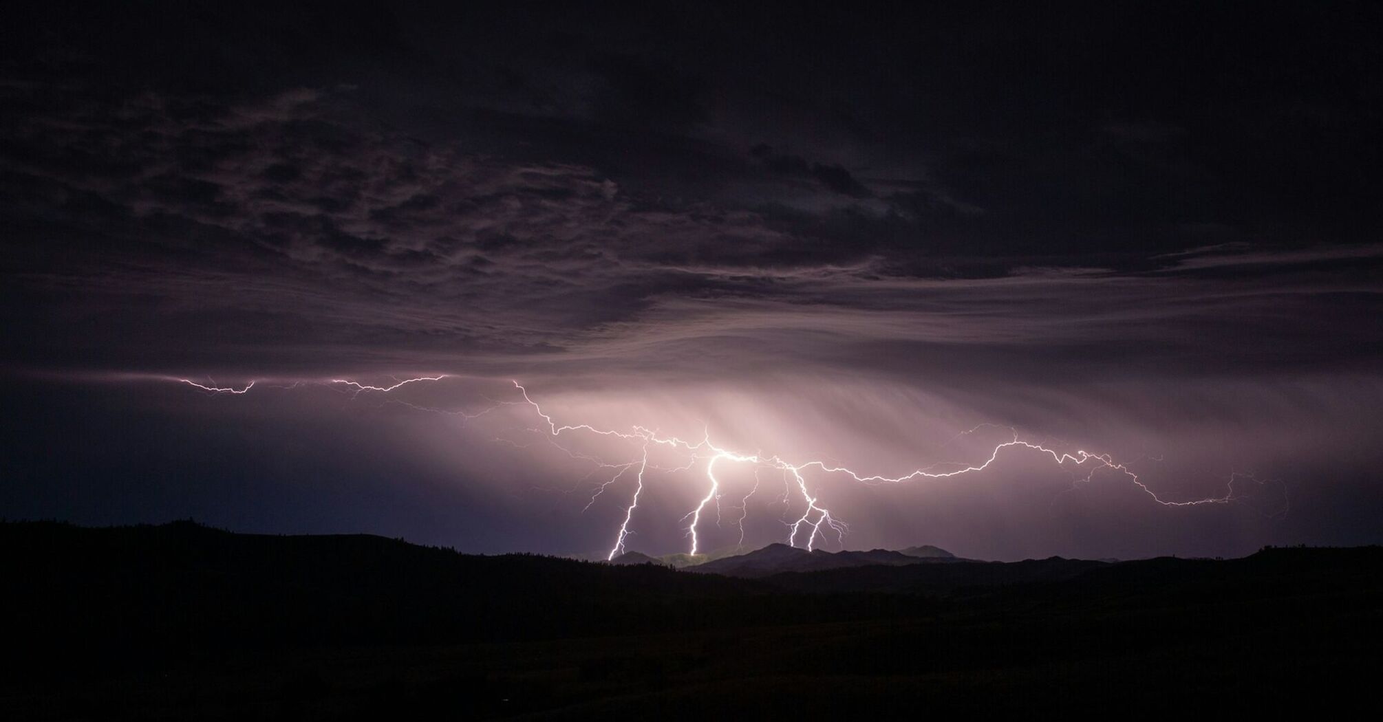 Lightning storm over a mountain landscape