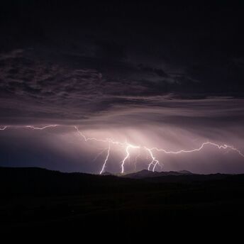 Lightning storm over a mountain landscape