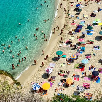Crowded Italian beach with parasols and swimmers