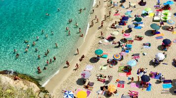 Crowded Italian beach with parasols and swimmers