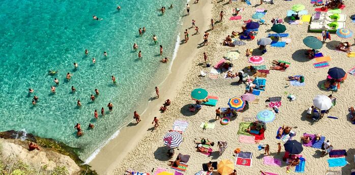 Crowded Italian beach with parasols and swimmers
