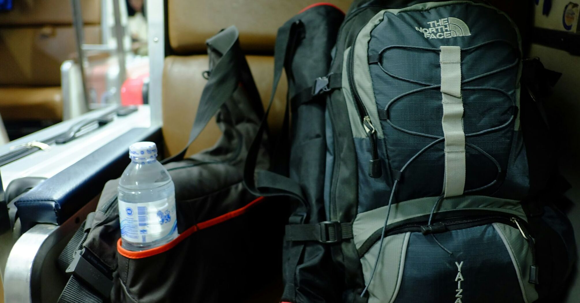 Travel backpack with water bottle beside it
