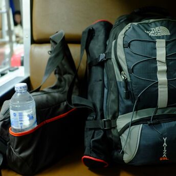 Travel backpack with water bottle beside it