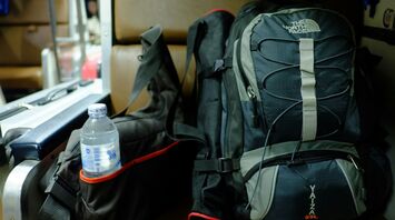 Travel backpack with water bottle beside it