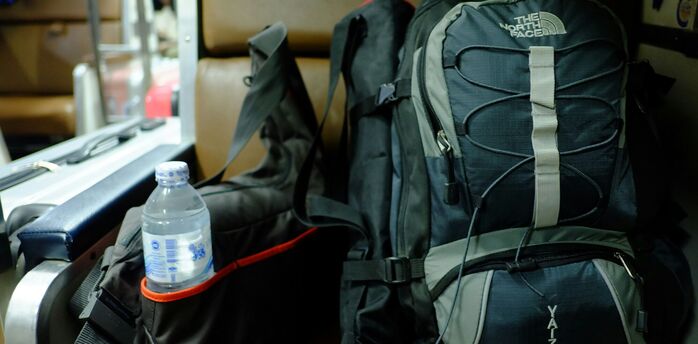 Travel backpack with water bottle beside it