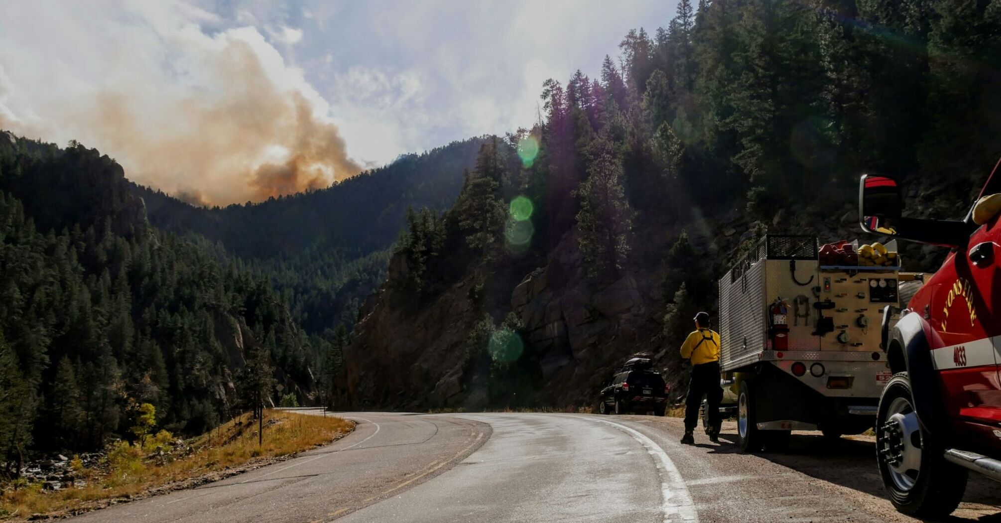 Fire crews monitoring smoke near a mountain road
