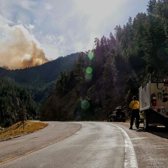 Fire crews monitoring smoke near a mountain road
