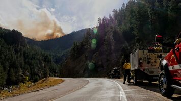 Fire crews monitoring smoke near a mountain road